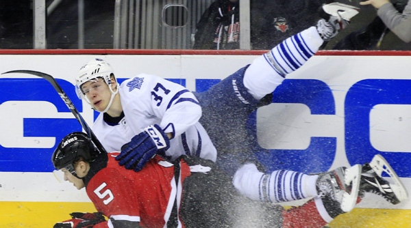 Toronto Maple Leafs' Carter Ashton (37) falls on top of New Jersey Devils' Adam Larsson (5), of Sweden, during the first period of an NHL hockey game in Newark, N.J., Friday, March 23, 2012. (AP Photo/Mel Evans)