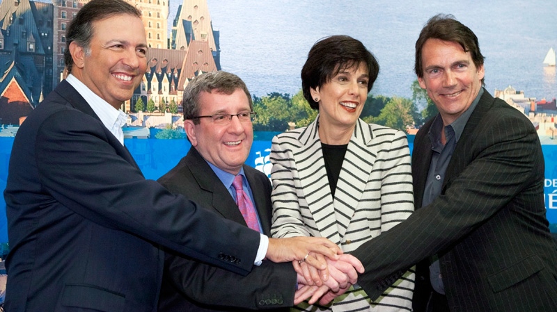 Quebecor president Pierre Karl Peladeau, from left, Quebec City Mayor Regis Labeaume, Quebec Treasury Board president Michelle Courchesne and Sam Hamad join hands after they announced they are going to proceed and build an arena Sunday, March 25, 2012 in Quebec City. (Jacques Boissinot / THE CANADIAN PRESS)