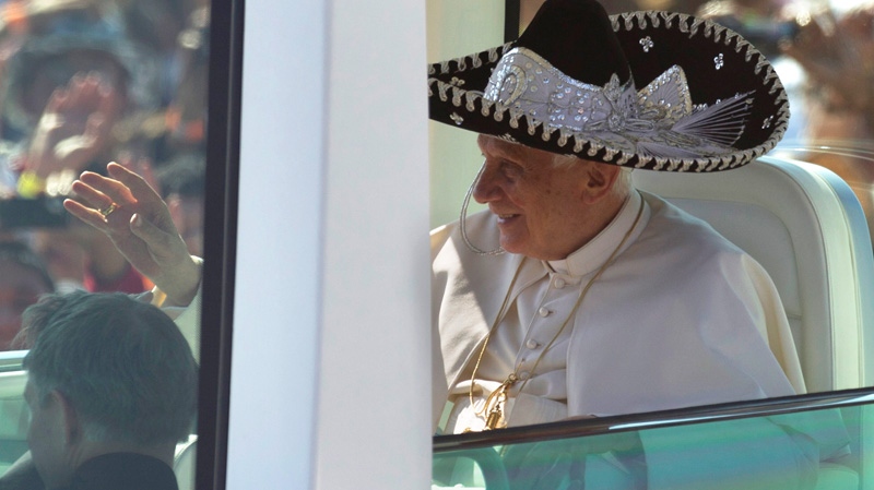 Pope Benedict XVI waves from the popemobile wearing a Mexican sombrero as he arrives to give a Mass in Bicentennial Park near Silao, Mexico, Sunday, March 25, 2012.