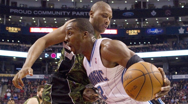 Orlando Magic's Dwight Howard (right) drives at Toronto Raptors' Jamaal Magloire during first half NBA basketball action in Toronto on Monday March 26, 2012. THE CANADIAN PRESS/Chris Young