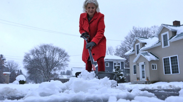 Lynette Johnson moves snow in front of her Mill Street home in Springville, N.Y., on Monday, Nov. 17, 2014. (AP Photo/The Buffalo News, Harry Scull Jr.)