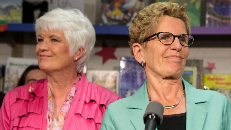 Ontario Premier Kathleen Wynne (right) stands with Education Minister Liz Sandals as she addresses the media at Westwood Public School in Guelph, Ontario on Wednesday, May 14, 2014. (Chris Young / THE CANADIAN PRESS)