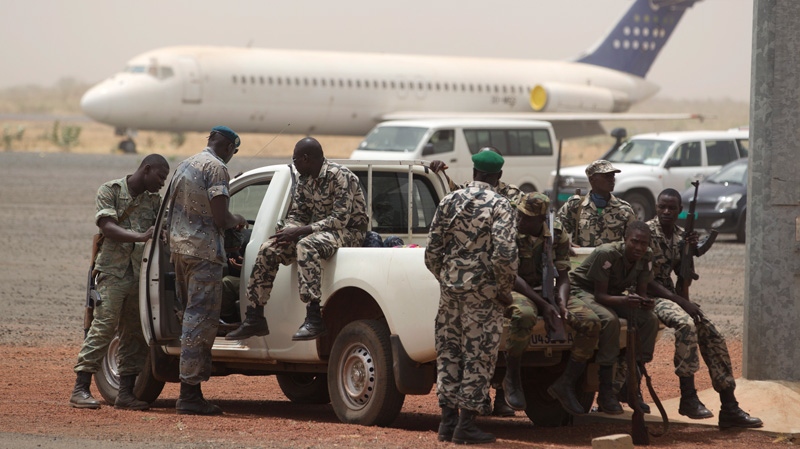 Soldiers sit guard on the tarmac of the international airport, where coup leader Capt. Amadou Haya Sanogo had been due to meet a delegation of West African presidents, in Bamako, Mali, Thursday, March 29, 2012. (AP / Rebecca Blackwell)