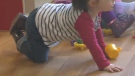 A young child crawls along the floor at a childcare centre (file)