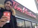 Karim Tanha holds up a coffee outside a Kitchener, Ont., Tim Hortons outlet on Thursday, Nov. 20, 2014. (Marc Venema / CTV Kitchener)