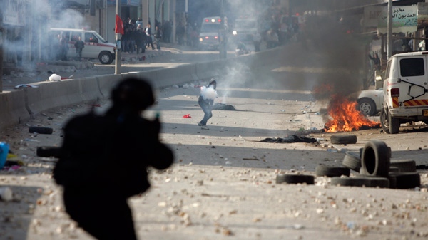 Israeli troops fire teargas at protesters during clashes at Kalandia checkpoint between Jerusalem and the West Bank city of Ramallah, Friday, March 30, 2012. (AP / Majdi Mohammed)