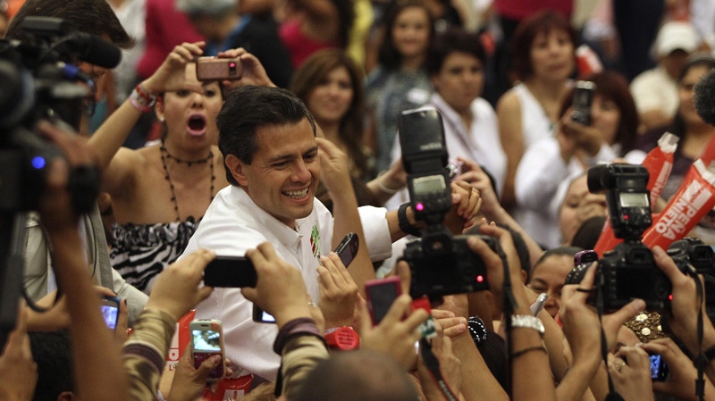 Presidential candidate Enrique Pena Nieto, of the Revolutionary Institutional Party (PRI), greets supporters during a campaign event with women in Guadalajara, Mexico, Friday March 30, 2012. (AP Photo/Bruno Gonzalez)