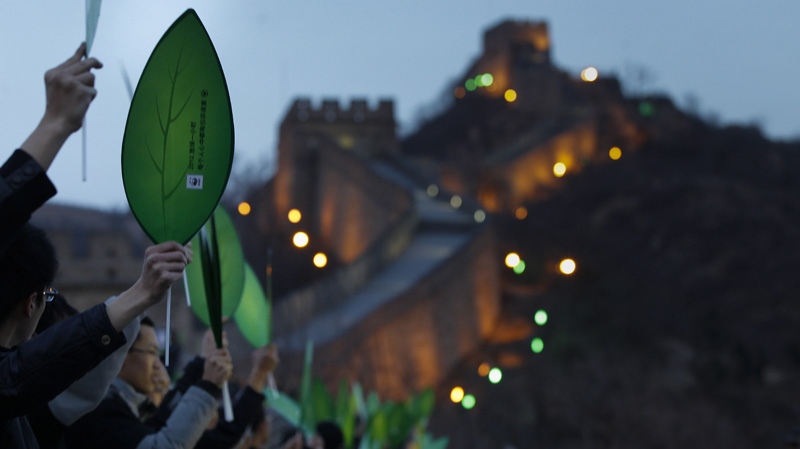 University students hold papers leaf to celebrate before a mini marathon in conjunction during the Earth Hour at the Great Wall of China in the north of Beijing, China, Saturday, March 31, 2012. (AP Photo/ Vincent Thian) 