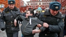 Russian police officers detain a protester during an unsanctioned opposition rally in Moscow, Russia