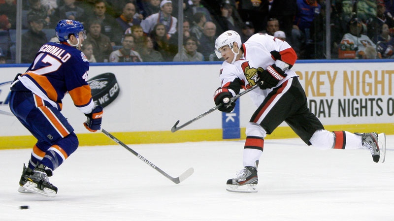 Ottawa Senators' Kyle Turris, right, takes a shot past New York Islanders' Andrew MacDonald during the third period of an NHL hockey game on Sunday, April 1, 2012, in Uniondale, N.Y. The Senators defeated the Islanders 5-1. (AP Photo/Seth Wenig)