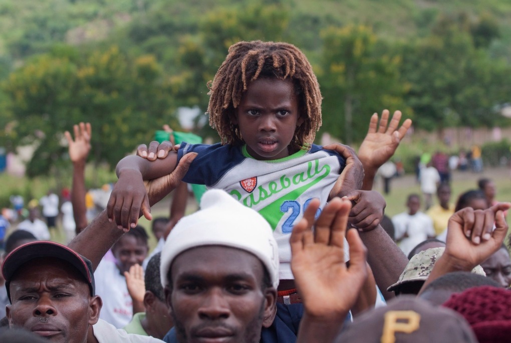 A young bo held up by father in Haiti