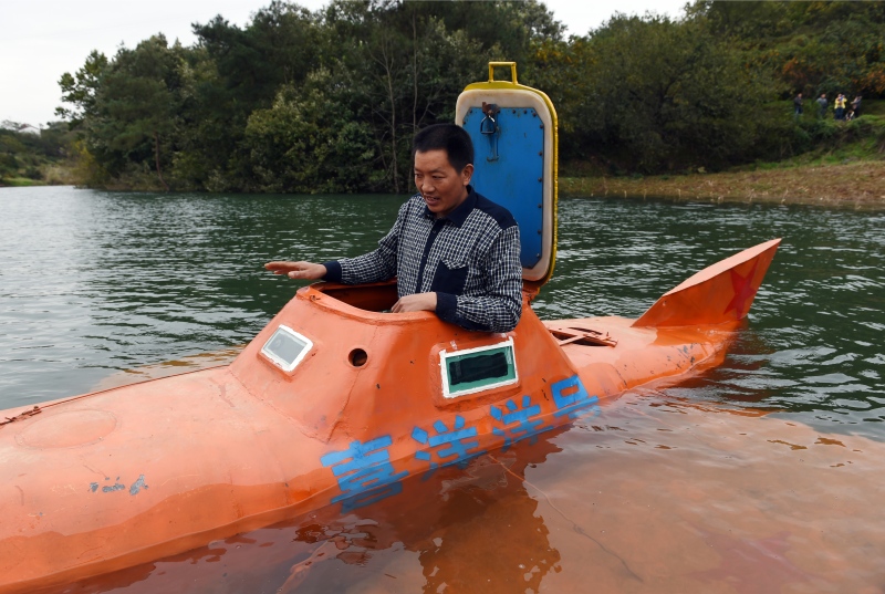 Tan Yong is preparing for a dive in his home-made submarine, on Danjiangkou reservoir, in China's central Hubei province. (©AFP PHOTO / Greg BAKER)