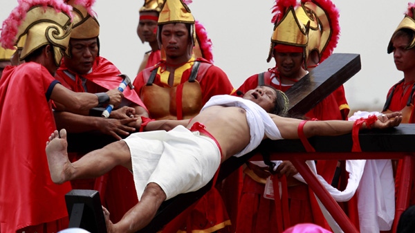 Ruben Enaje reacts as nails are driven to his palms in a reenactment of the crucifixion of Jesus Christ on Good Friday at San Pedro Cutud, Pampanga province, north of Manila, Philippines Friday, April 6, 2012. More than two dozen Catholic devotees have themselves nailed on the cross on Good Friday, a practice rejected by the Catholic Church but has become a tourist attraction.(AP Photo/Bullit Marquez)