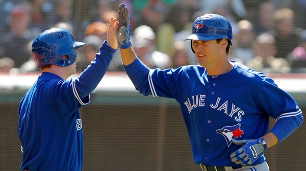Toronto Blue Jays' Kelly Johnson, right, is congratulated by teammate Adam Lind after he hit a solo home run in the ninth inning against the Cleveland Indians in Cleveland on Saturday, April 7, 2012. (AP / Amy Sancetta)