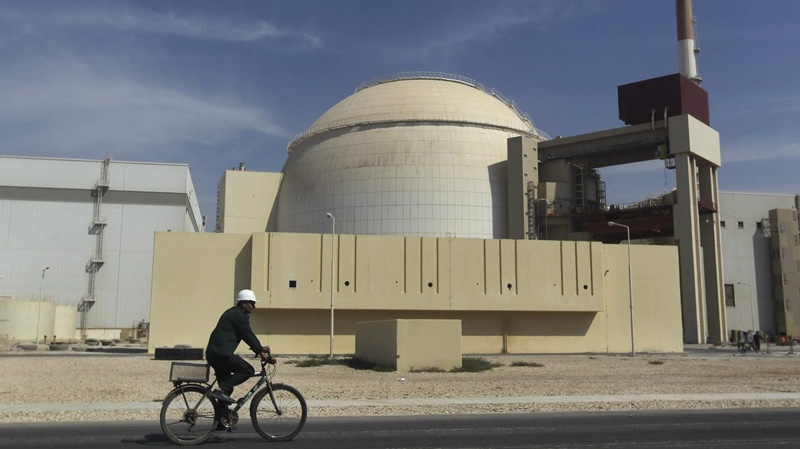 In this Tuesday, Oct. 26, 2010 file photo, a worker rides a bike in front of the reactor building of the Bushehr nuclear power plant, just outside the southern city of Bushehr, Iran. (AP Photo/Mehr News Agency, Majid Asgaripour, File)