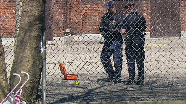 Police are shown investigating the scene of a deadly shooting near a playground in Hamilton on Saturday, April 7, 2012.