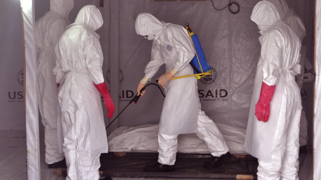 Ebola workers spray man's body in Liberia
