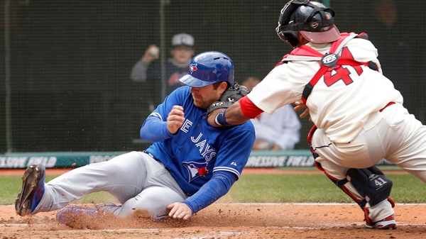 Toronto Blue Jays' Adam Lind slides safely into home, beating the tag by Cleveland Indians catcher Carlos Santana in the fourth inning of a baseball game in Cleveland on Sunday, April 8, 2012. (AP / Amy Sancetta)
