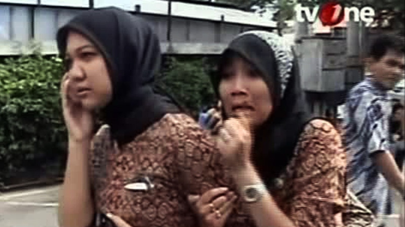 Two women react on a street shortly after they ran out from a building when a strong earthquake hit in Aceh in Indonesia, Wednesday, April 11, 2012. (TV One via AP Video)