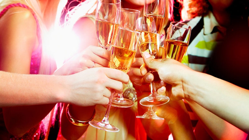 Holiday party goers drink sparkling wine