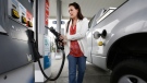 Lydia Holland replaces the gas nozzle after filling up at a gas station in Sacramento, Calif., Nov. 12, 2014. (AP / Rich Pedroncelli)