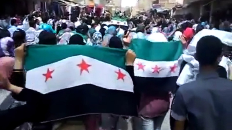 This image made from amateur video purports to show Syrians holding Syrian revolutionary flags during a demonstration in Deir el-Zour, Syria, on Thursday, April 12, 2012. (Ugarit News via AP video)