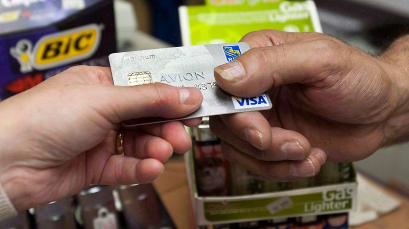 A consumer pays with a credit card at a store in Montreal on July 6, 2010. (Ryan Remiorz / THE CANADIAN PRESS)