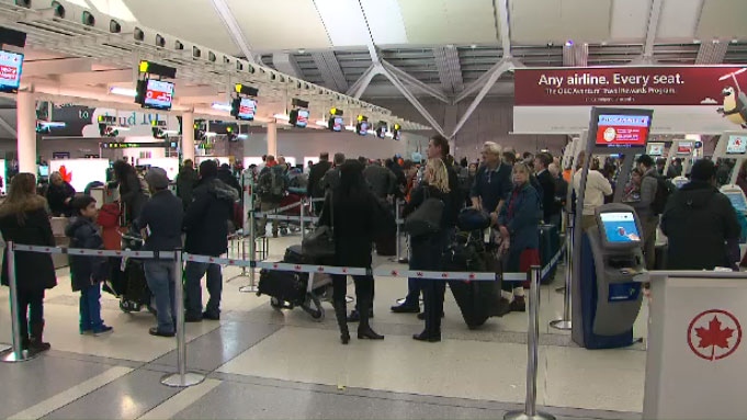 Travellers wait in line at Toronto's Pearson International Airport on Thursday, Dec. 11, 2014. 