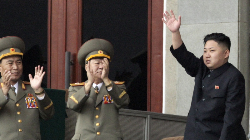North Korean leader Kim Jong Un, left waves as North Korean military officers clap during a mass meeting of North Korea's ruling party at a stadium in Pyongyang, North Korea on Saturday April 14, 2012. (AP Photo/Ng Han Guan)
