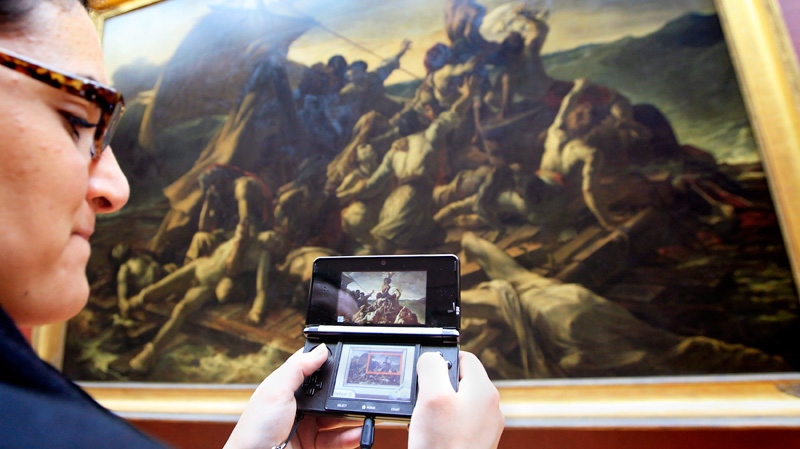A visitor studies a painting "The Raft of the Medusa" by French artist Theodore Gericault 1791 - 1824 with the help of the new audio guide at the Louvre Museum in Paris, Thursday, April 12, 2012. (AP / Jacques Brinon)