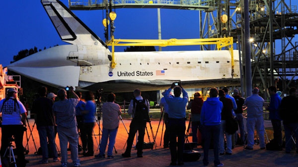 News media crews document work on attaching the space shuttle Discovery to a modified 747 that will ferry the shuttle to the Smithsonian in Washington, using the Shuttle Mate Demate device at the Kennedy Space Center in Cape Canaveral, Fla., early Sunday morning, April 15, 2012. (Florida Today / Craig Rubadoux)