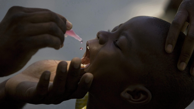 In this March 26, 2009 file photo, a health official gives drops of oral polio vaccination to a child at the Mission of Mercy school in the Cite Soleil slum, in Port-au-Prince. (AP Photo/Ramon Espinosa)