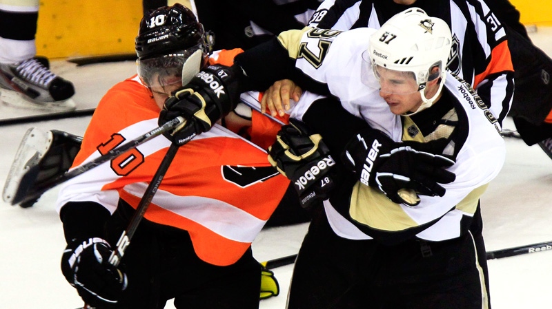 Pittsburgh Penguins' Sidney Crosby, right, shoves his glove and stick into the face of Philadelphia Flyers Brayden Schenn during a multi-fight brawl in front of the benches during the third period of Game 3 in a first-round NHL Stanley Cup playoffs hockey series, Sunday, April 15, 2012, in Philadelphia. (AP / Tom Mihalek)