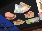 Cash and a weapon seized by OPP as part of Project Pinecreek are displayed in London, Ont., on Friday, Dec. 19, 2014.