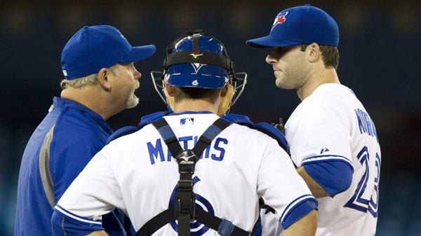 Toronto Blue Jays starting pitcher Brandon Morrow (right) talks with catcher Jeff Mathis and pitching coach Bruce Walton (left) on the mound during fourth inning AL action against the Tampa Bay Rays in Toronto on Wednesday April 18, 2012. THE CANADIAN PRESS/Frank Gunn