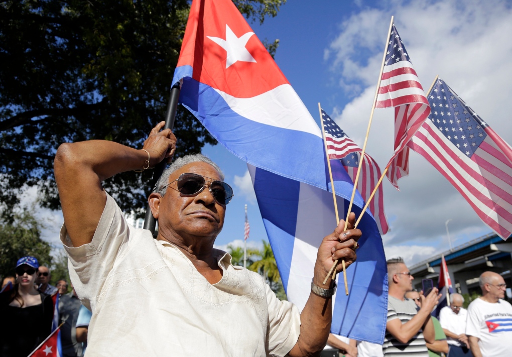 Evilio Ordonez holds Cuban and American flags