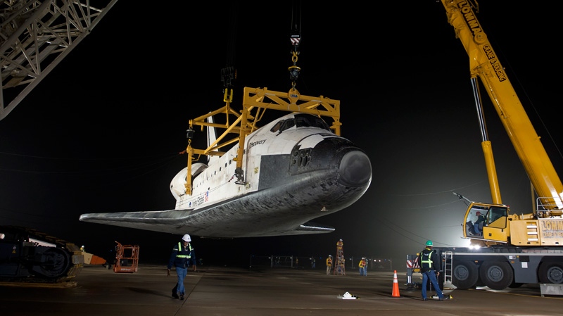 space shuttle Discovery is suspended from a sling held by two cranes after the Boeing 747 carrier backed away at Washington Dulles International Airport, Thursday, April 19, 2012, in Sterling, Va.(NASA / Bill Ingalls) 