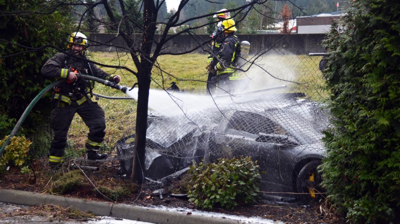 Fire crews spray water on a Lamborghini that crashed through a chain-link fence on Sunday, Dec. 21, 2014. (CTV)