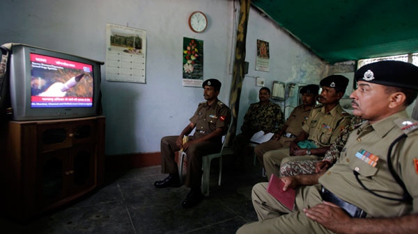 Indian Border Security Force officers watch television coverage of the launch of India's Agni-V missile at their base near Amritsar, Thursday, April 19, 2012. (AP / Altaf Qadri)
