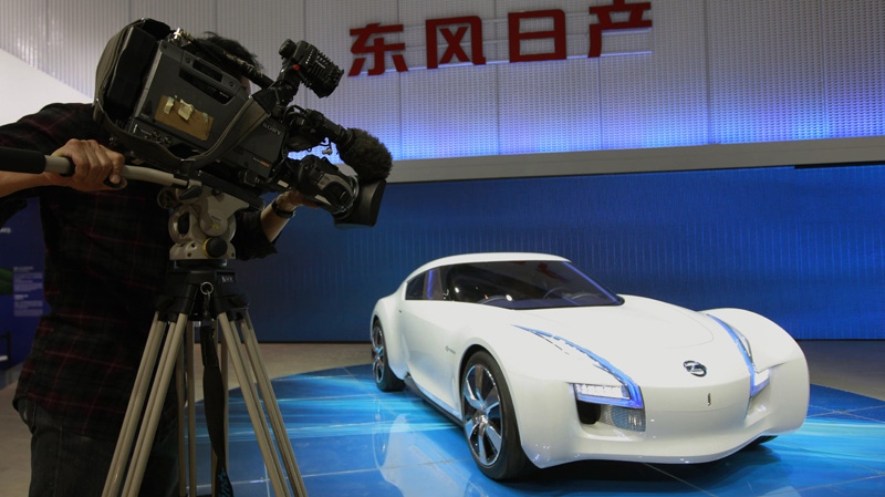 A cameraman films Nissan's latest concept and electronic car the Esflow at the Beijing International Auto Exhibition in Beijing, China, Monday, April 23, 2012. (AP Photo/ Vincent Thian)