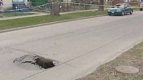 Crews taped off Ingersoll Street after a sinkhole formed near Ellice Avenue in Winnipeg on April 25, 2012. 