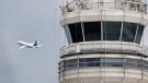 A passenger jet flies past the FAA control tower at Washington's Ronald Reagan National Airport, on March 24, 2011. (AP / Cliff Owen)