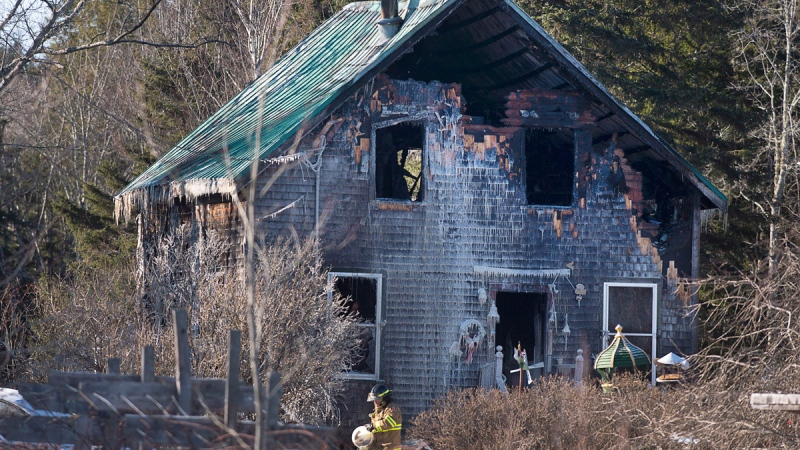 A firefighter works at the scene of a fatal house fire near Wyses Corner, N.S., outside of Halifax, on Thursday, Jan. 8, 2015. (Andrew Vaughan / THE CANADIAN PRESS)