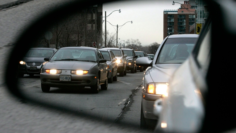 Commuters are reflected in a rearview mirror while sitting in rush hour traffic in Toronto in this March 4, 2008 photo. (J.P. Moczulski/THE CANADIAN PRESS)