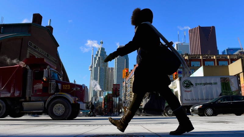 A woman walks in downtown Toronto. (Frank Gunn / The Canadian Press)