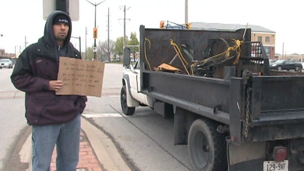 A police officer disguised as a panhandler waits to give a distracted driver a ticket in Burlington on Tuesday, May 1, 2012.