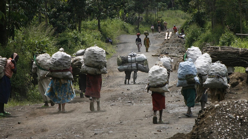 In this Nov. 19, 2008 women and traders travel from the charcoal market in Rupango, eastern Congo, through Kimoka. (AP Photo/Jerome Delay)