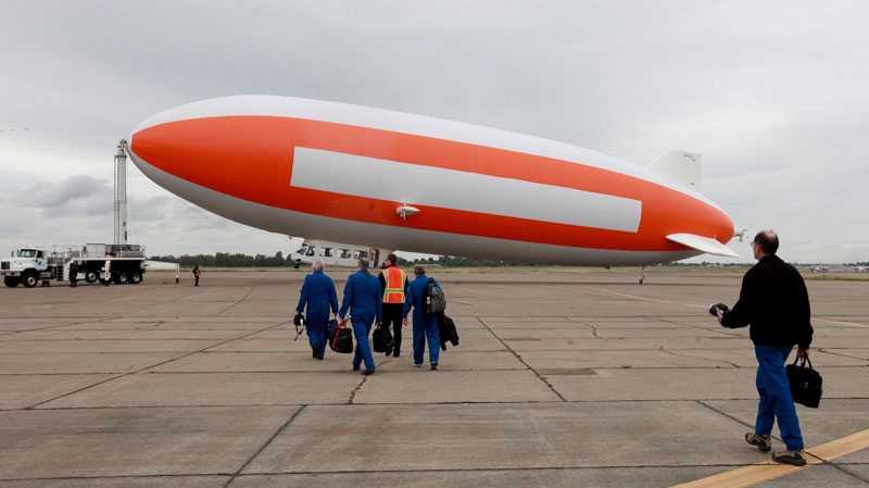 Peter Jenniskens, right, the NASA scientist in charge of a group of researchers searching for pieces of a meteorite, walk to the zeppelin, Eureka, at McClellan Air Park in Sacramento, Calif., Thursday, May 3, 2012. (AP / Rich Pedroncelli)