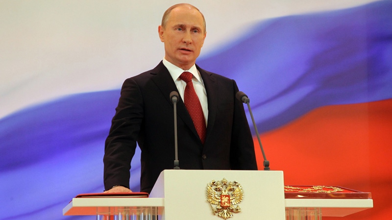 Vladimir Putin speaks with his hand on the Constitution during his inauguration ceremony as new Russia's president in Moscow Monday, May 7, 2012. (RIA Novosti Kremlin, Vladimir Rodionov, Presidential Press Service)