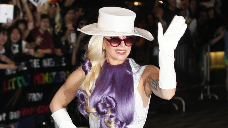 U.S. pop singer Lady Gaga waves to fans on her arrival at a hotel in Hong Kong Saturday, April 28, 2012. (AP Photo/Kin Cheung)